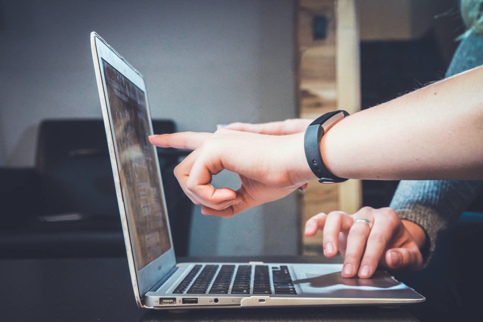 Someone pointing at a laptop screen while working through IT support